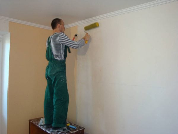 Man primers walls after puttying