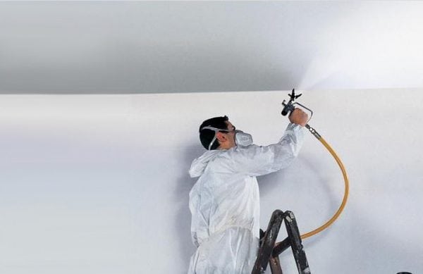 A man is applying a primer to a wall