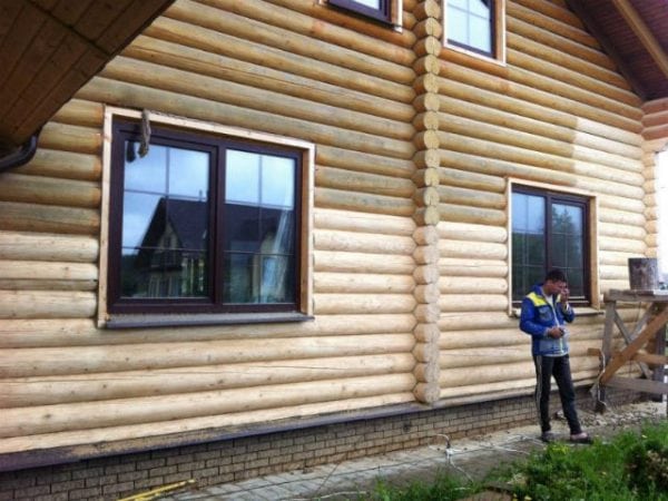 A man paints a blockhouse