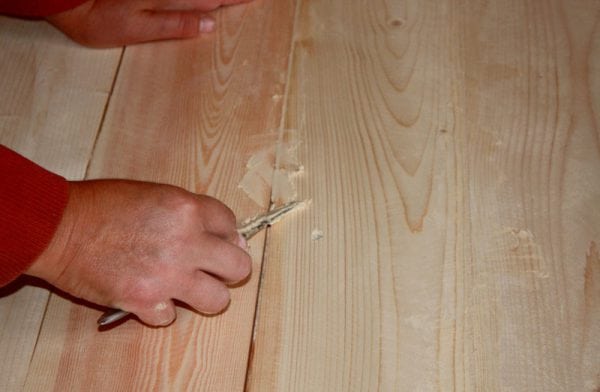 Un homme crache sur un plancher en bois