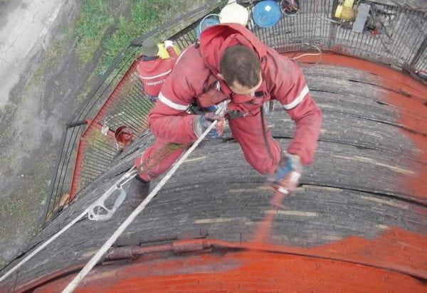 Le processus de peinture de la cheminée avec un pistolet pulvérisateur