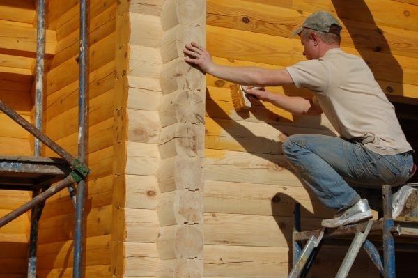 The process of painting the walls of a wooden house