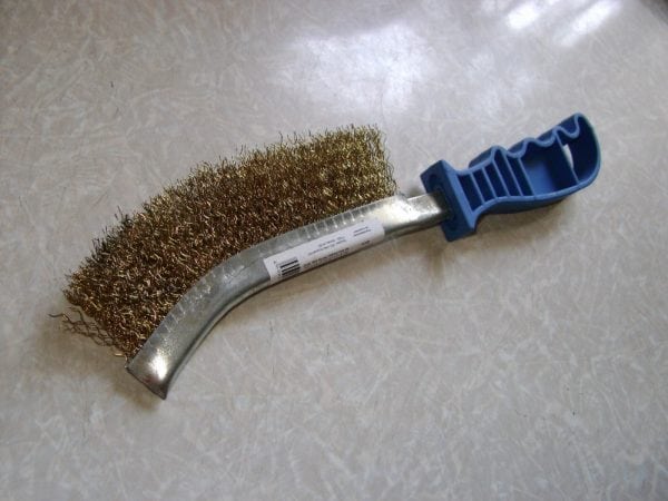 Metal brush for cleaning the tank