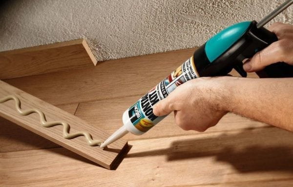 Memperbaiki papan skirting kayu ke kuku cecair