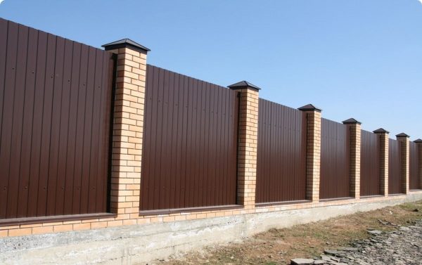 Corrugated fence with brick pillars