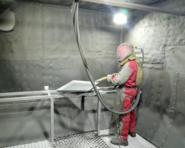 Inhabited shot blasting chamber