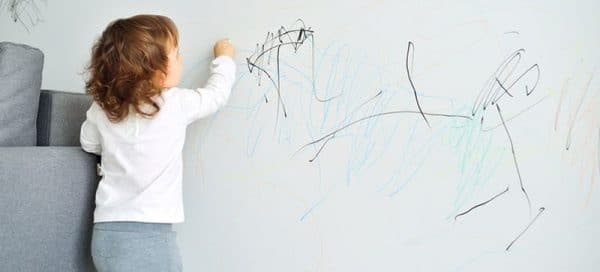 Child painting on wallpaper