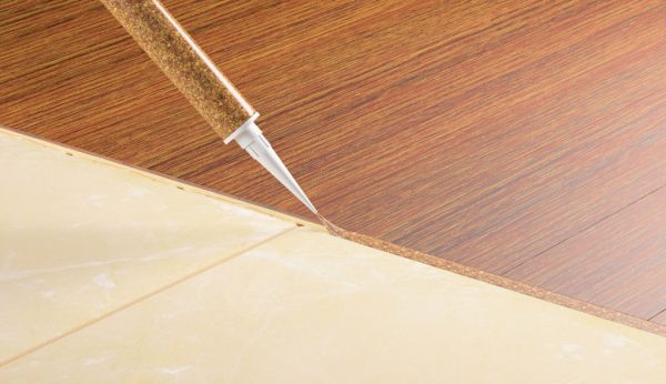 Joint sealing between tile and laminate