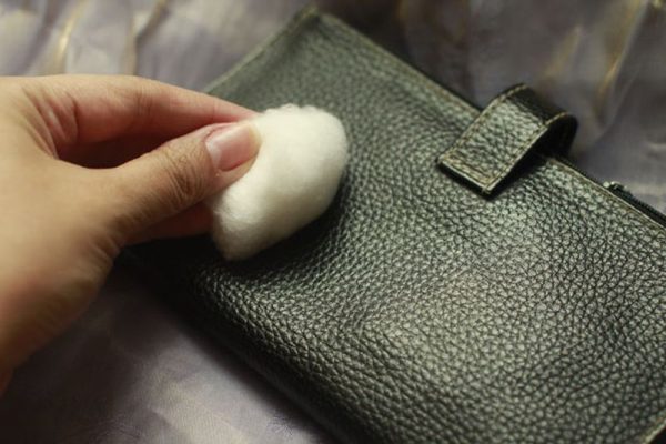 Removing stains from your wallet with a cotton swab