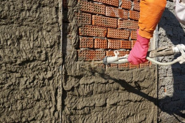 Spraying plaster mortar onto a wall