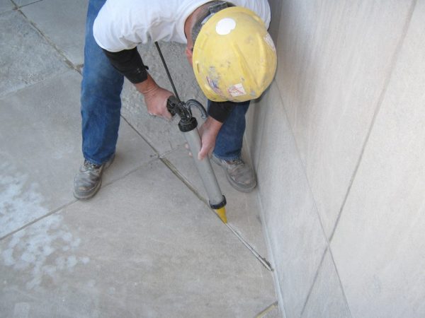 Remplissage de joints dans un sol en béton à partir d'une seringue de construction