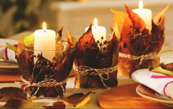 Candles with autumn leaves in the interior decoration