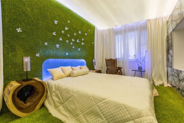 Artificial grass on the wall in the bedroom interior